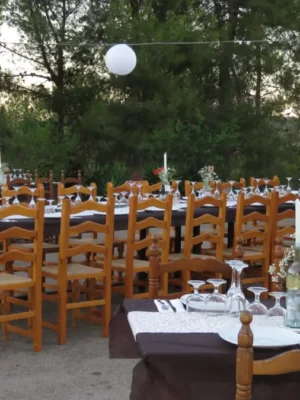 Montaje banquete boda El Regajo - Sillas de madera y decoración floral Valencia Mesas decoradas boda rústica El Regajo - Celebración exterior con iluminación Valencia